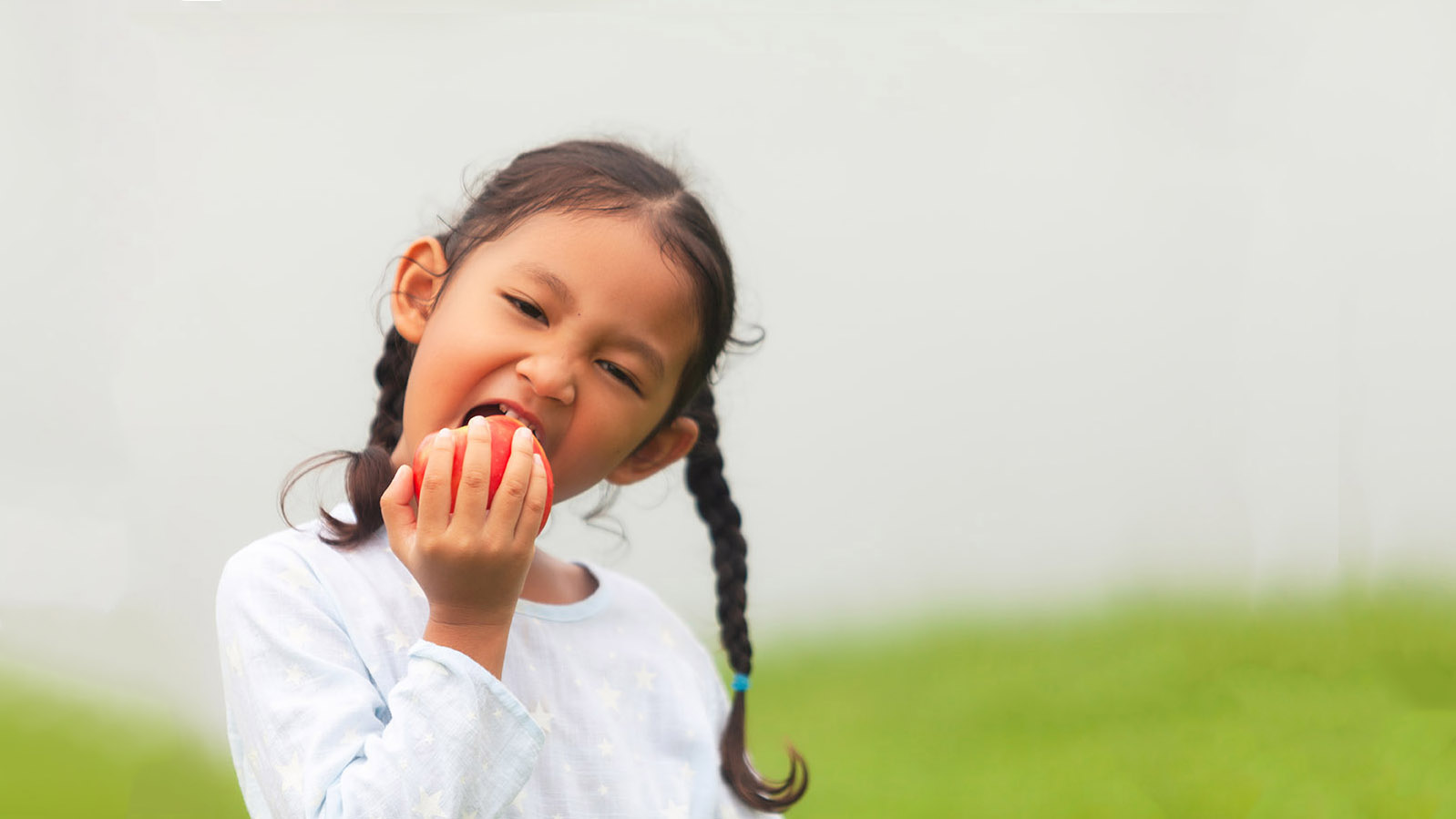 Young girl eating apple