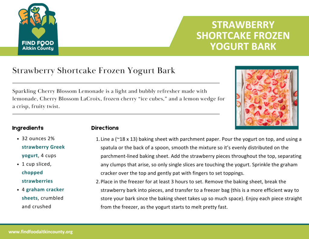 A sheet of strawberry shortcake frozen yogurt bark made with a base of strawberry Greek yogurt, topped with fresh strawberry slices and crumbled graham crackers. The bark is broken into uneven pieces and displayed on parchment paper, showing a vibrant mix of pink yogurt, red fruit, and golden cracker bits—frozen and ready to enjoy.